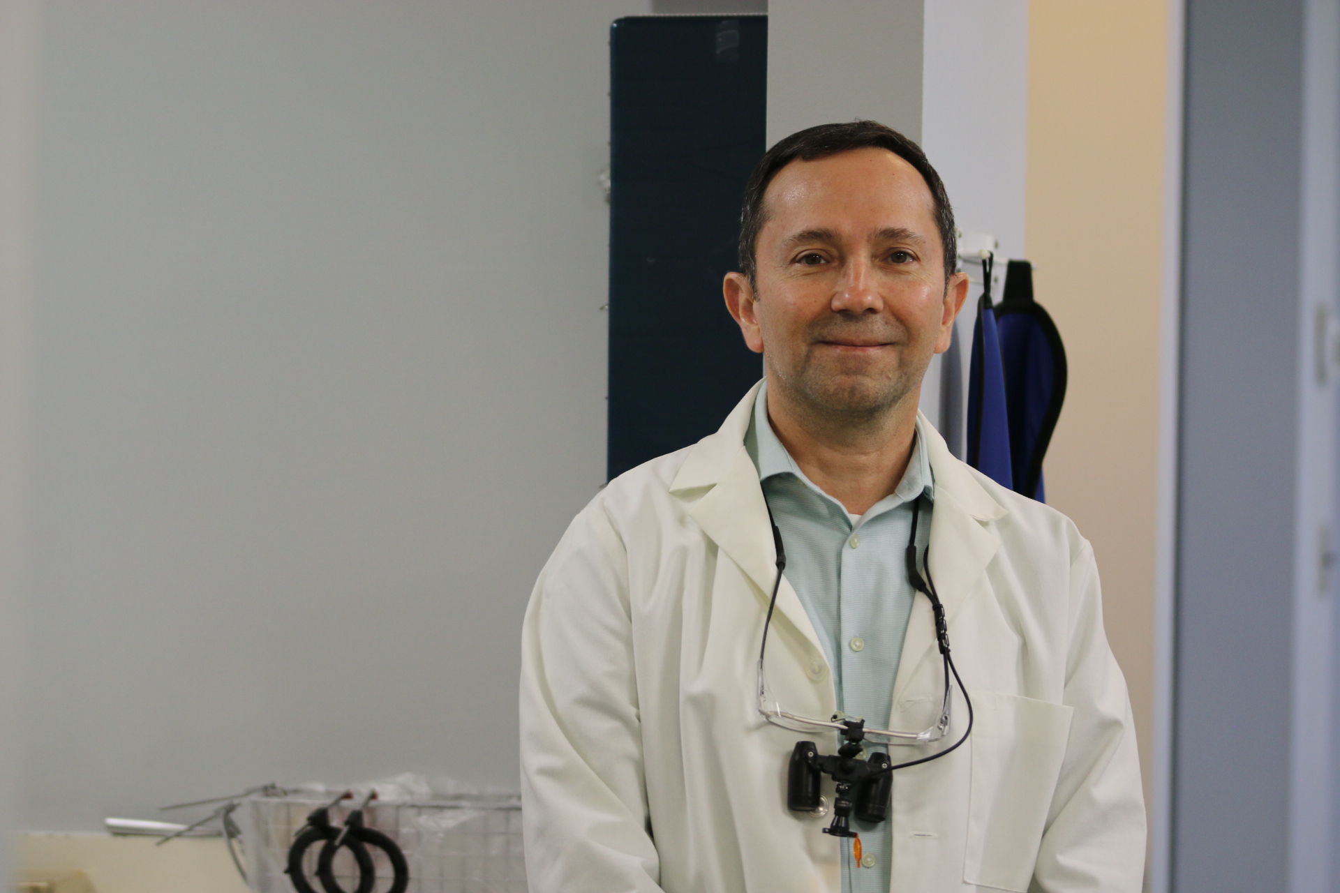 Dr. Victor J. Dongo wearing his white coat in a treatment room