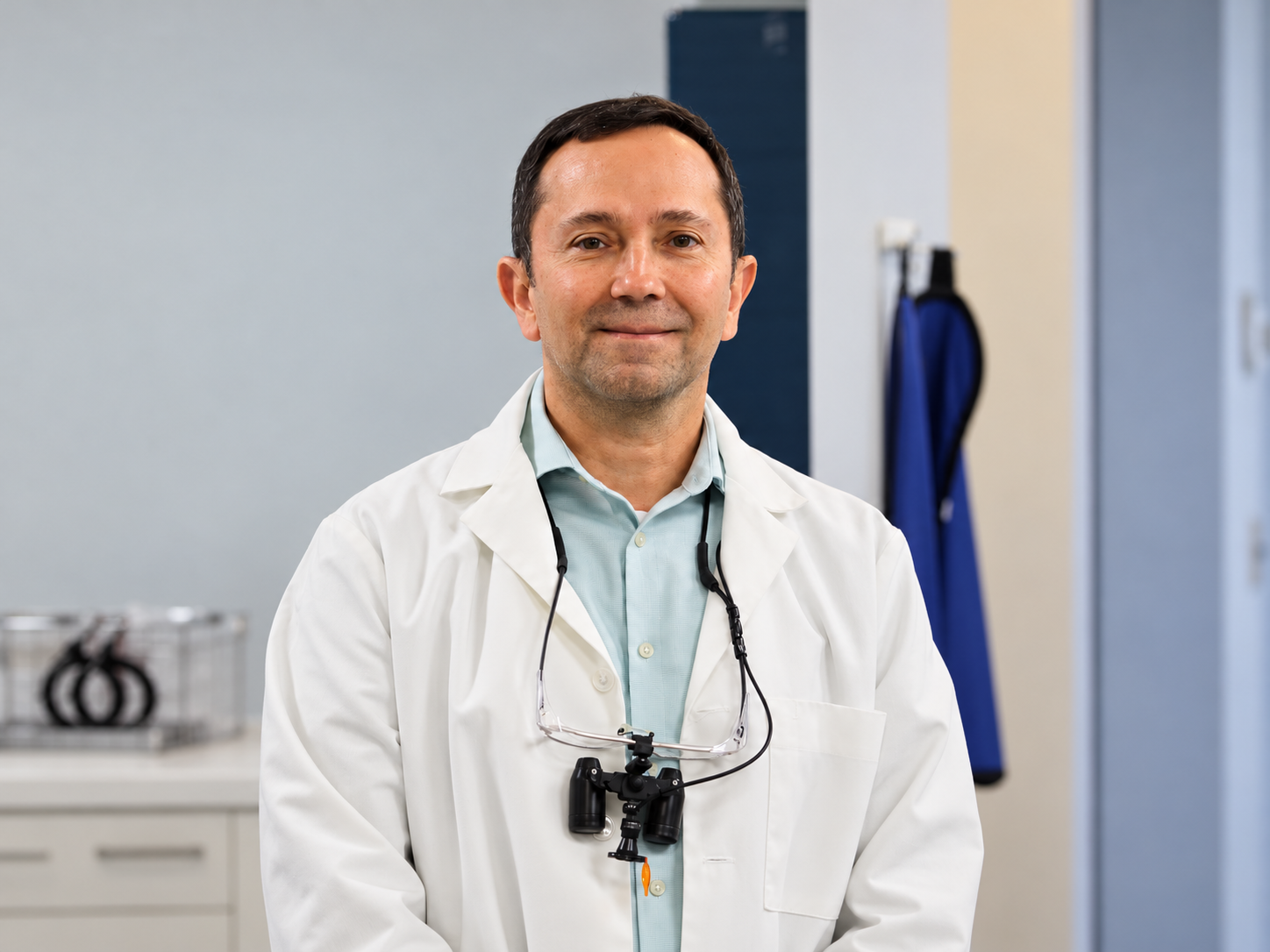 Dr. Victor J. Dongo wearing his white coat in a treatment room
